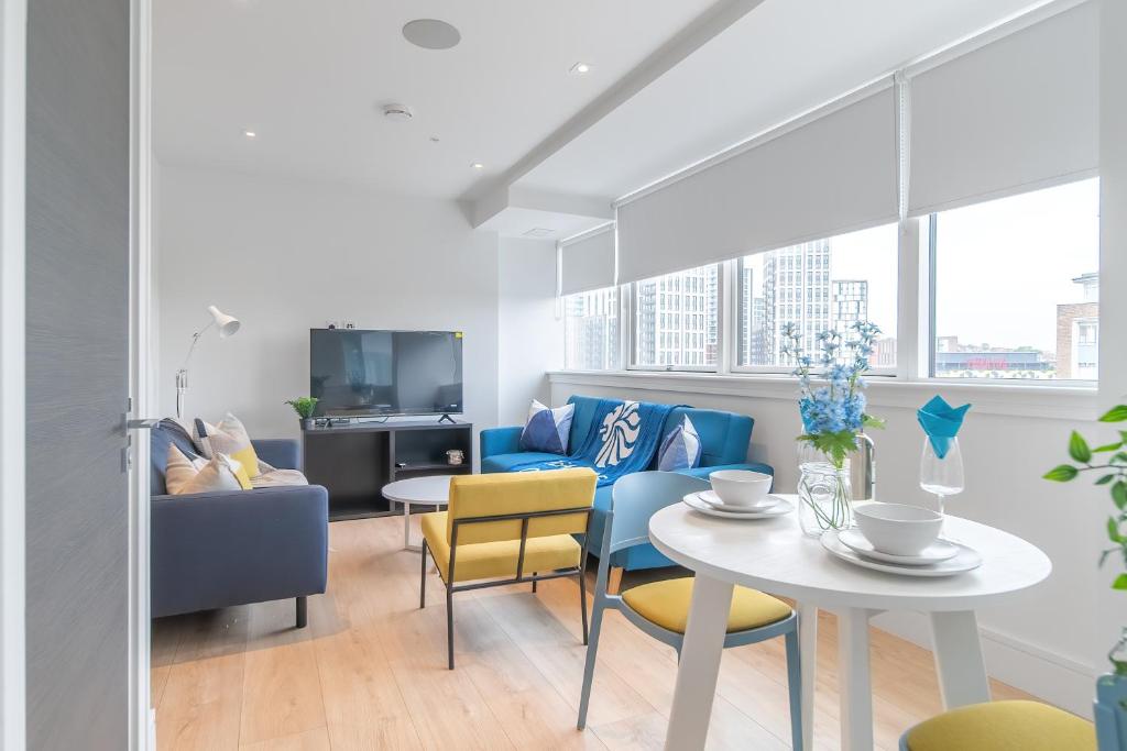 un soggiorno con tavolo e sedie di Livestay-Modern Apartments Next To Wembley Stadium a Londra