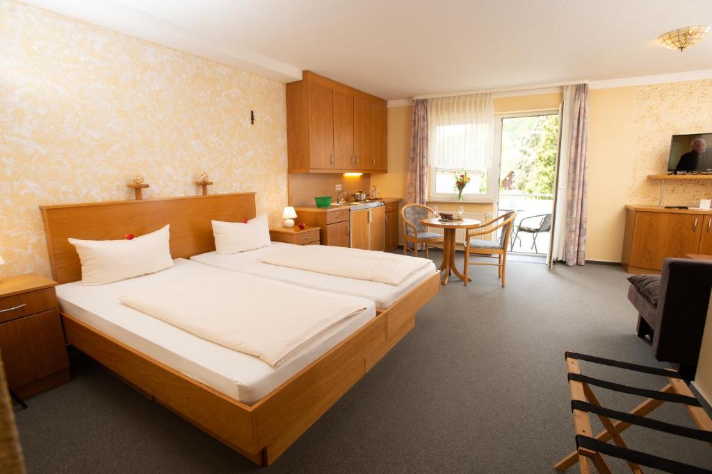 a bedroom with a large bed and a table at Landhotel zum Stern in Waldkappel
