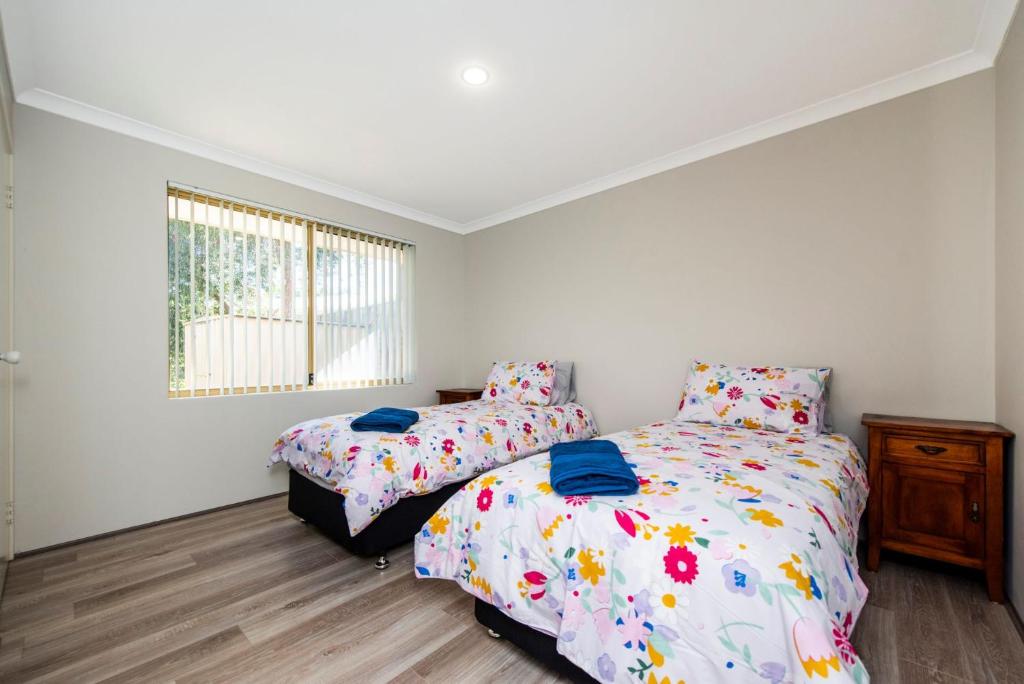 a bedroom with two beds and a window at Waves And Moore - Beautifully presented home in Guilderton