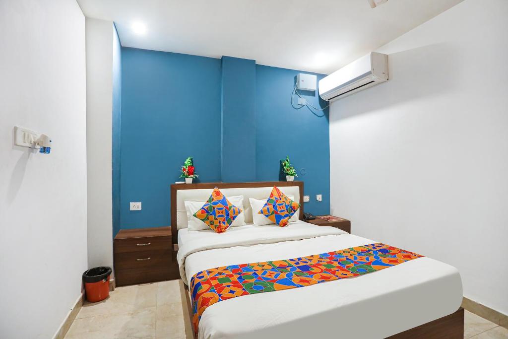 Un dormitorio con una pared azul y una cama en FabHotel Usha Continental, en Muthiganj
