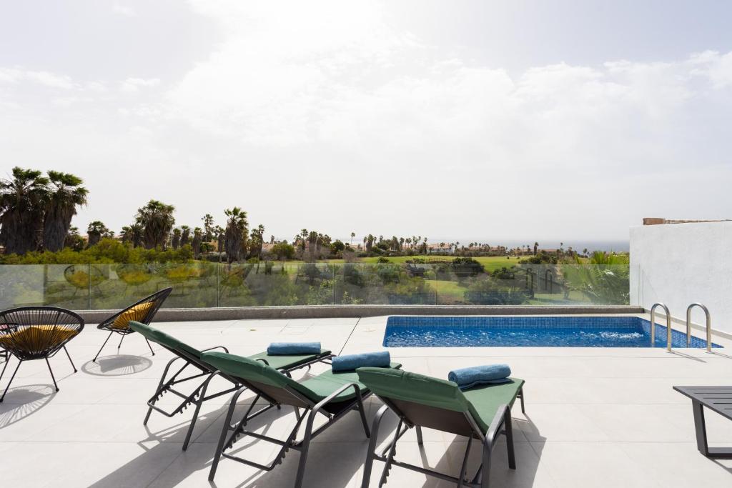 un patio con sillas y una piscina en Joy Tenerife Charming House, en San Miguel de Abona