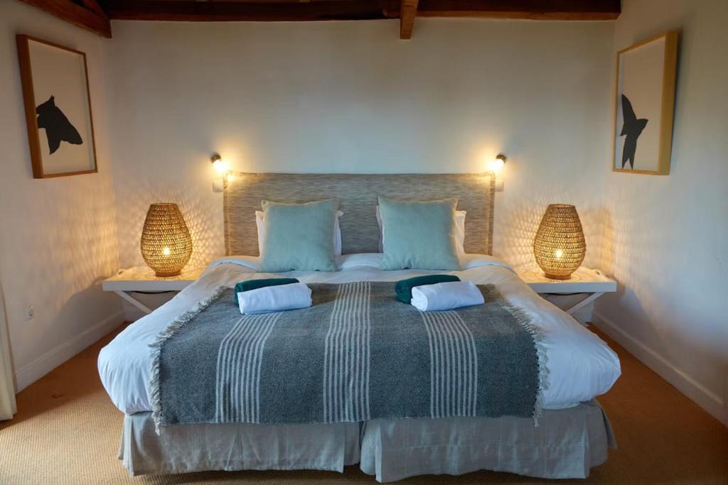 een slaapkamer met een groot bed met 2 lampen bij Quinta das Vinhas in Calheta