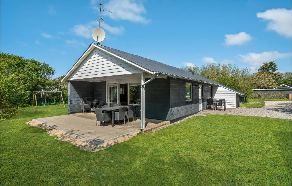 een zwart huis met een tafel en stoelen in een tuin bij 3 Bedroom Lovely Home In Vestervig in Vestervig