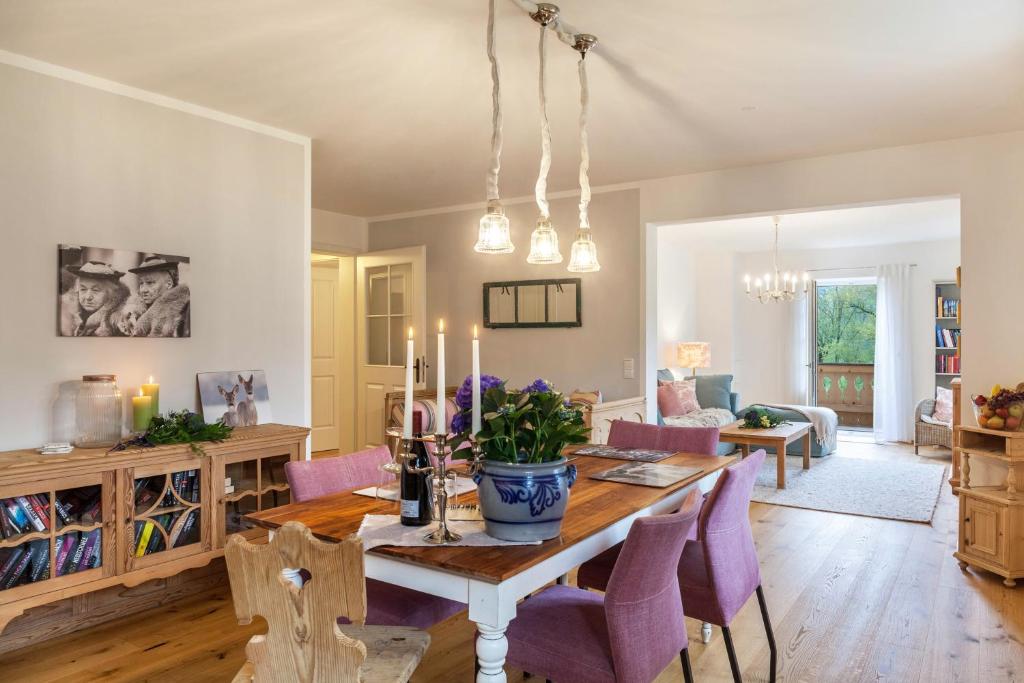 a dining room and living room with a table and purple chairs at Lina in Rottenbuch