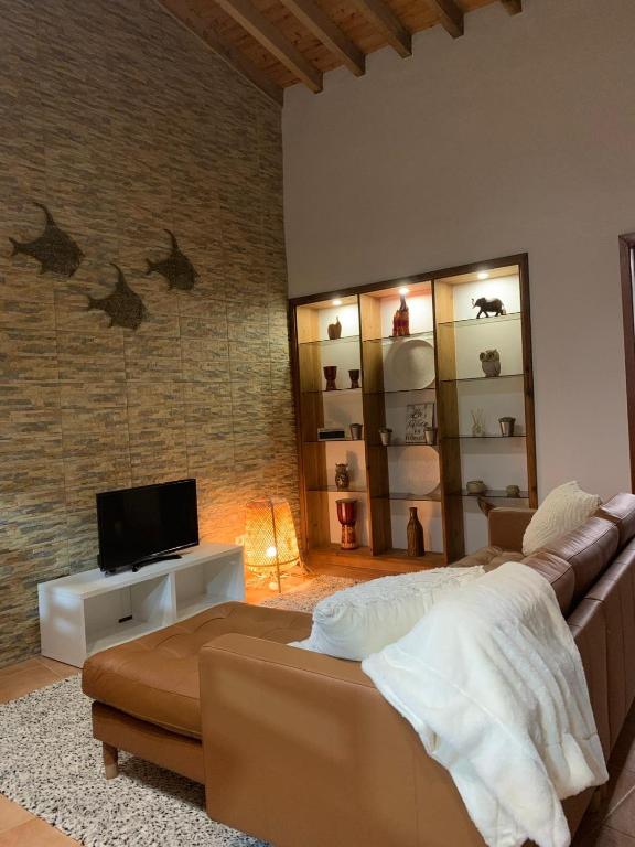 a living room with a couch and a tv at Vivenda do Cielo in Salga