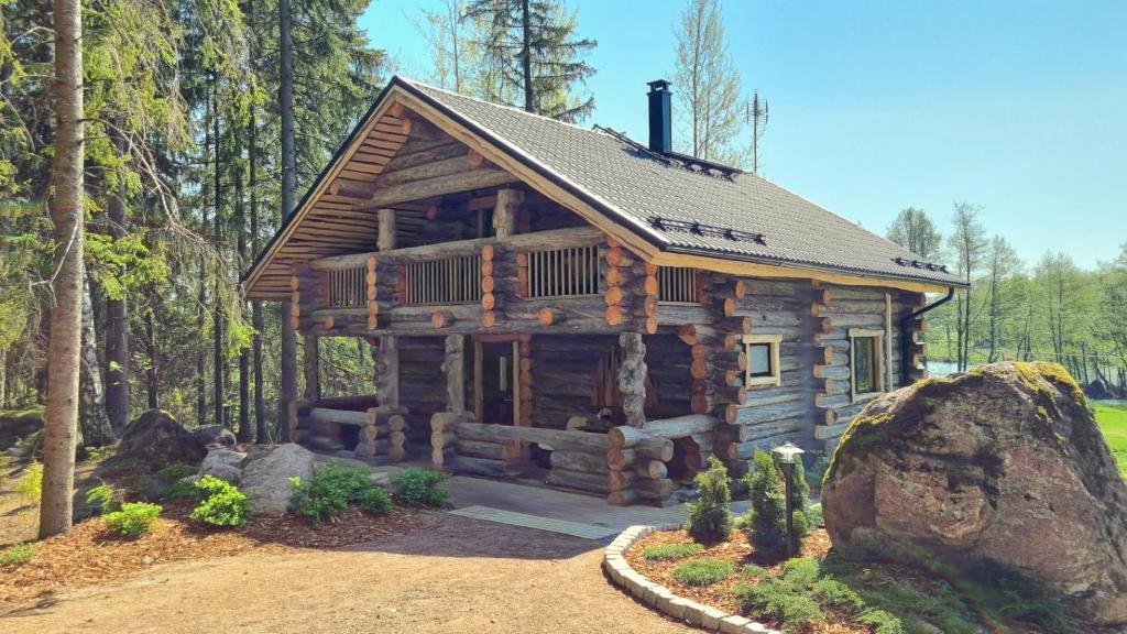 una baita di tronchi in mezzo a una foresta di Villa Kaunisvirta a Utbyn