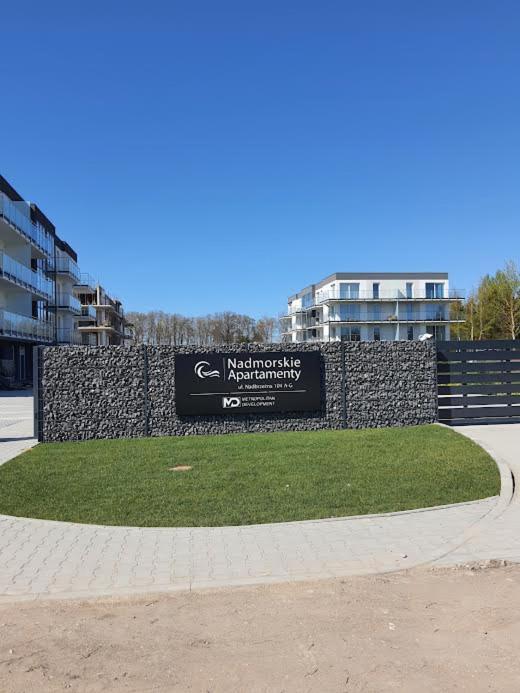 a sign in a park in front of a building at Nadmorski Apartament in Gąski