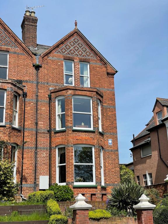 a red brick house with a large window at The Raffles in Exeter