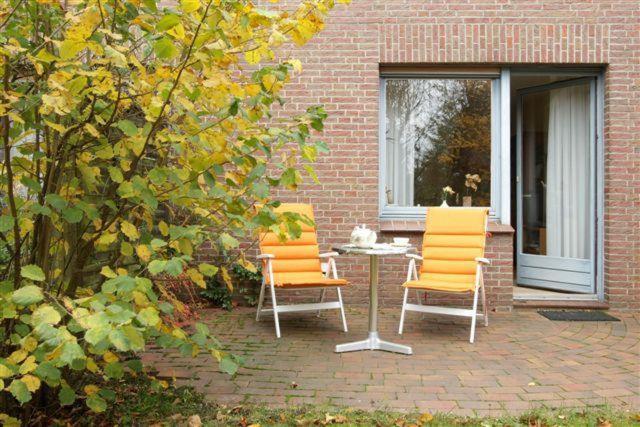 two chairs and a table in front of a building at Ferienwohnung Familie Weihe in Reppenstedt
