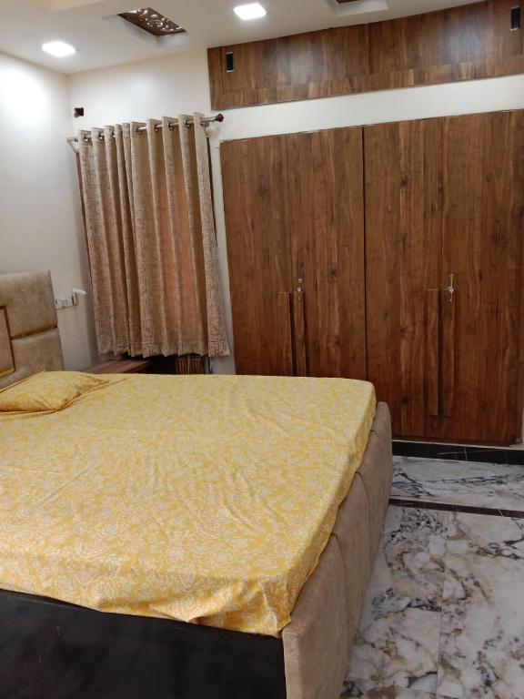 a bedroom with a large bed and wooden cabinets at Gupta Residence. in Dhanbād