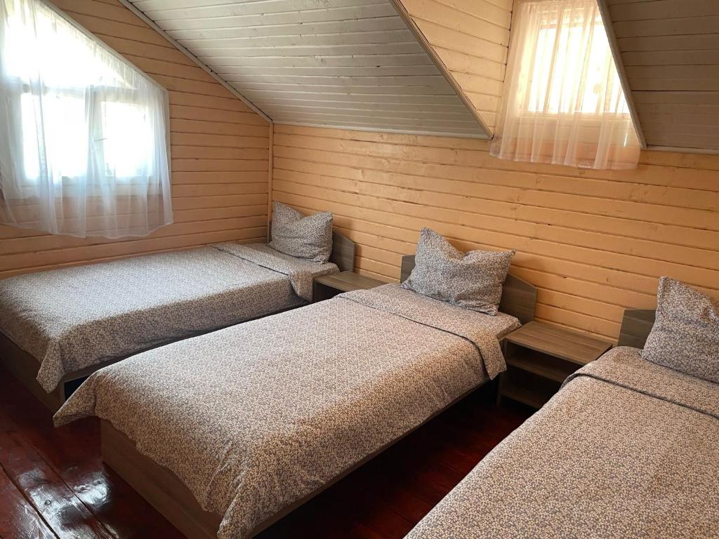a room with three beds and two windows at Casa B&amp;P in Costinesti
