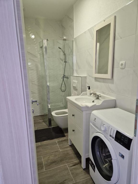 a bathroom with a washing machine and a washer at Apartmani Biskup in Dugi Rat