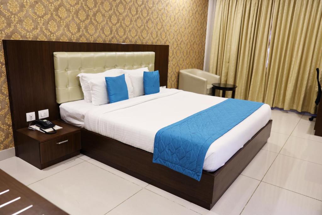 a bedroom with a large bed with blue pillows at Blue Ocean Residency in Bangalore
