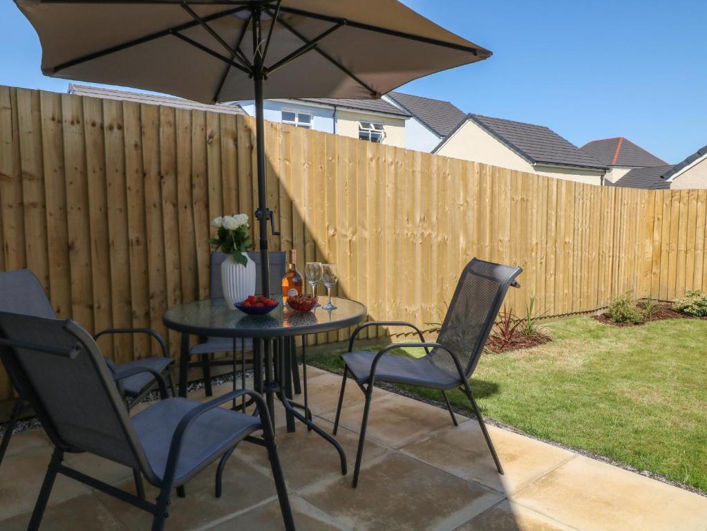 a table with chairs and an umbrella on a patio at Pebble Bay in Bideford
