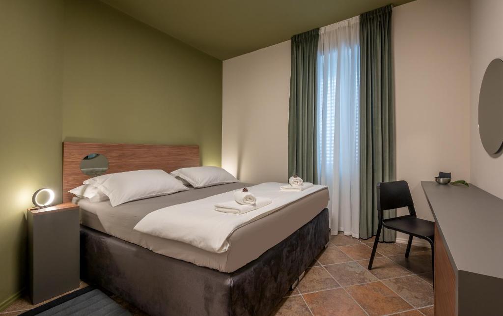 a bedroom with a bed with a desk and a chair at Green, deluxe two bedroom suite in Split