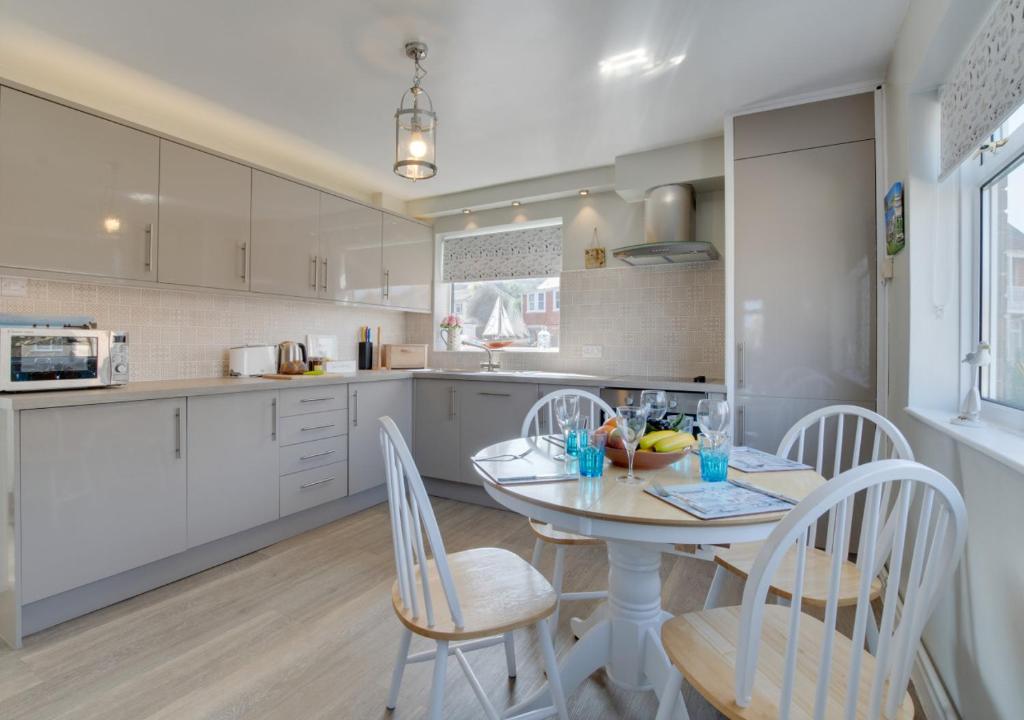 a kitchen with a table and chairs in a kitchen at The Retreat 1 Alexandra Court in Swanage