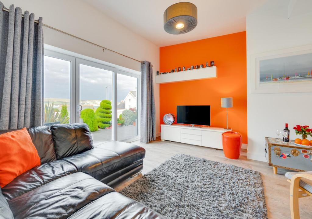 een woonkamer met een bank en een tv bij SeaBreeze Holiday Apartment in Swanage