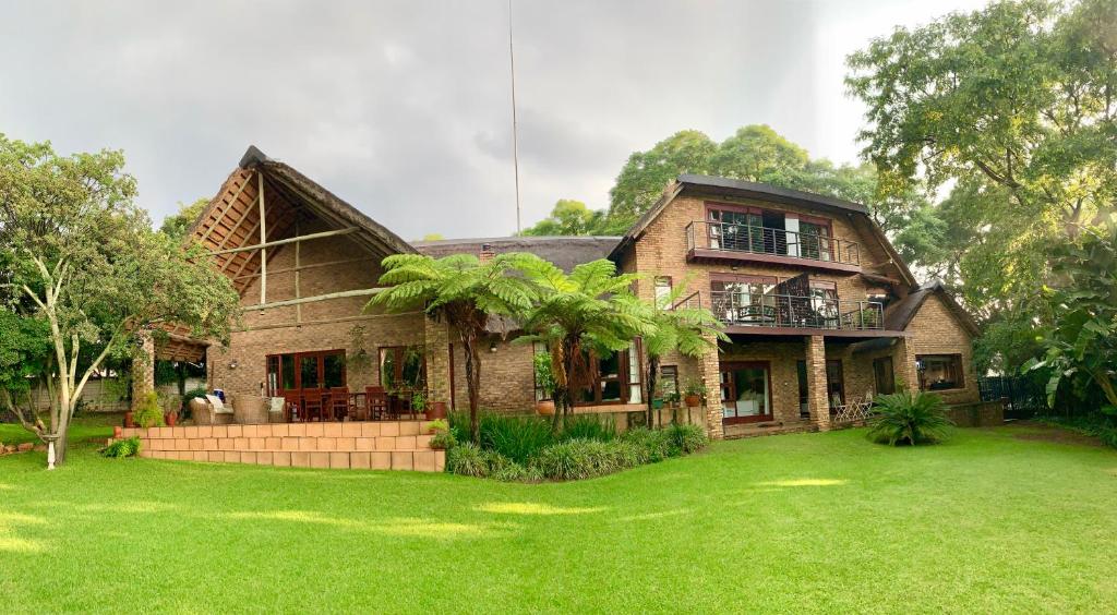 una gran casa de ladrillo con césped delante en Shepherd Lodge, en Johannesburgo