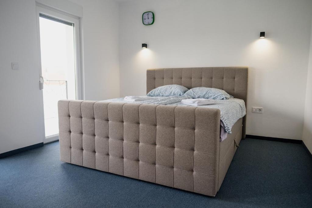 ein großes Bett in einem Schlafzimmer mit einer großen gepolsterten Matratze in der Unterkunft CIOM Apartment in Matuzići