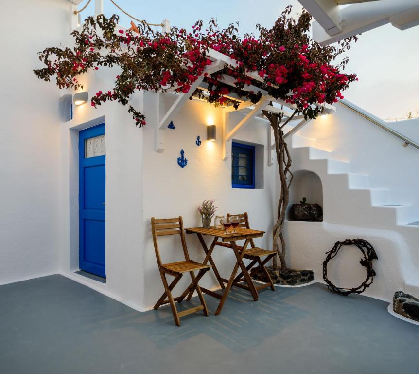 a room with a blue door and a table and chairs at Casa Delle Botti Cave House Santorini Oia Finikia in Foinikiá