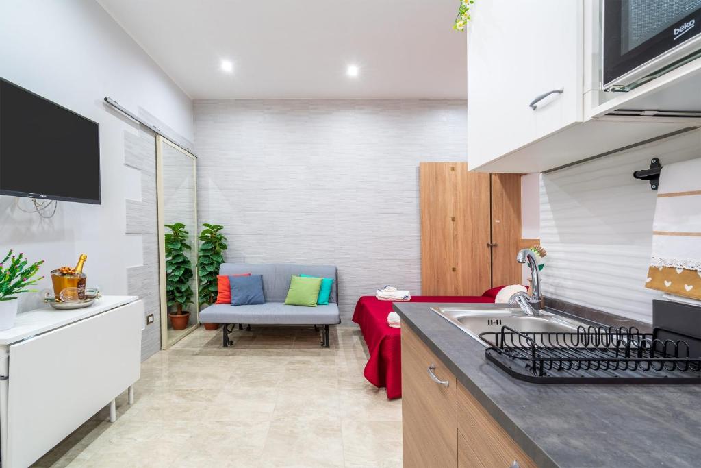 eine Küche mit einem Waschbecken und einem Sofa in einem Zimmer in der Unterkunft Dimora D&G in Syrakus