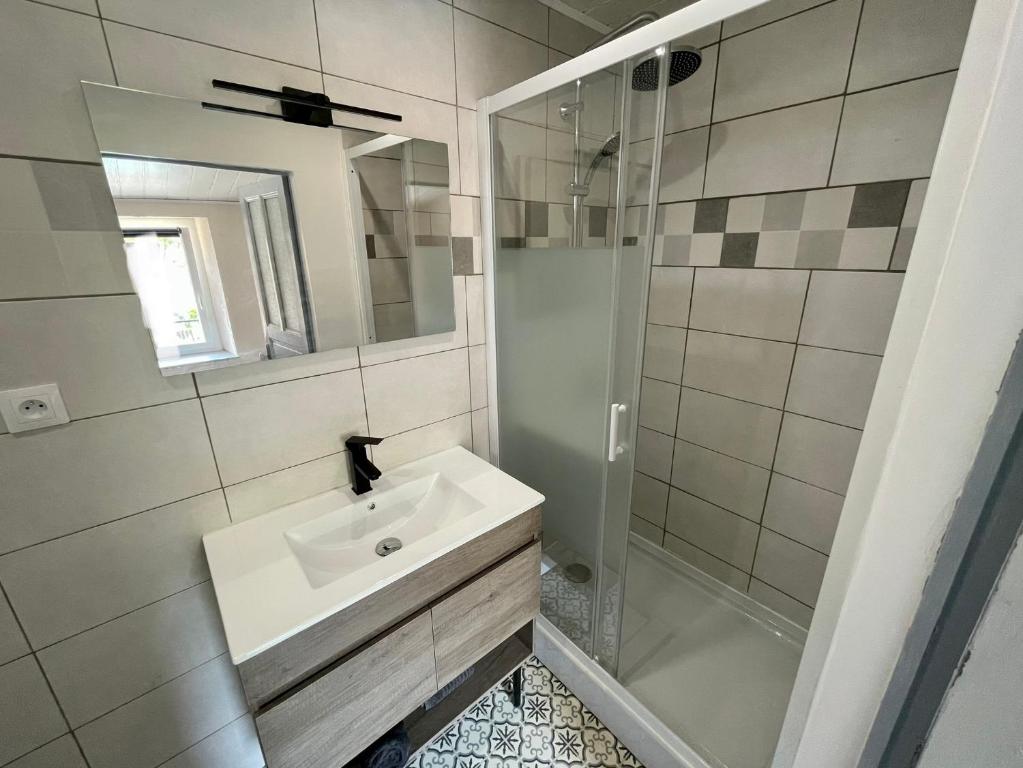 a white bathroom with a sink and a shower at Douceur occitane in Saint-Chinian