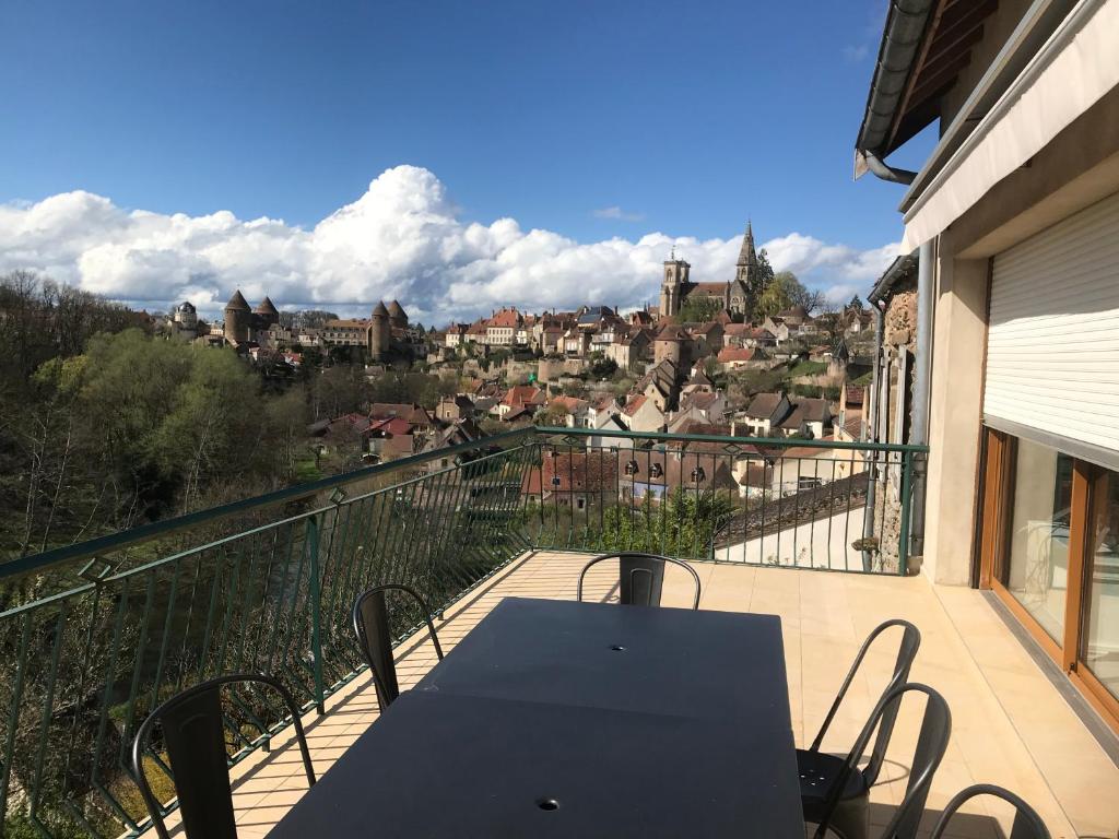 a table on a balcony with a view of a city at gite du viaduc in Semur-en-Auxois