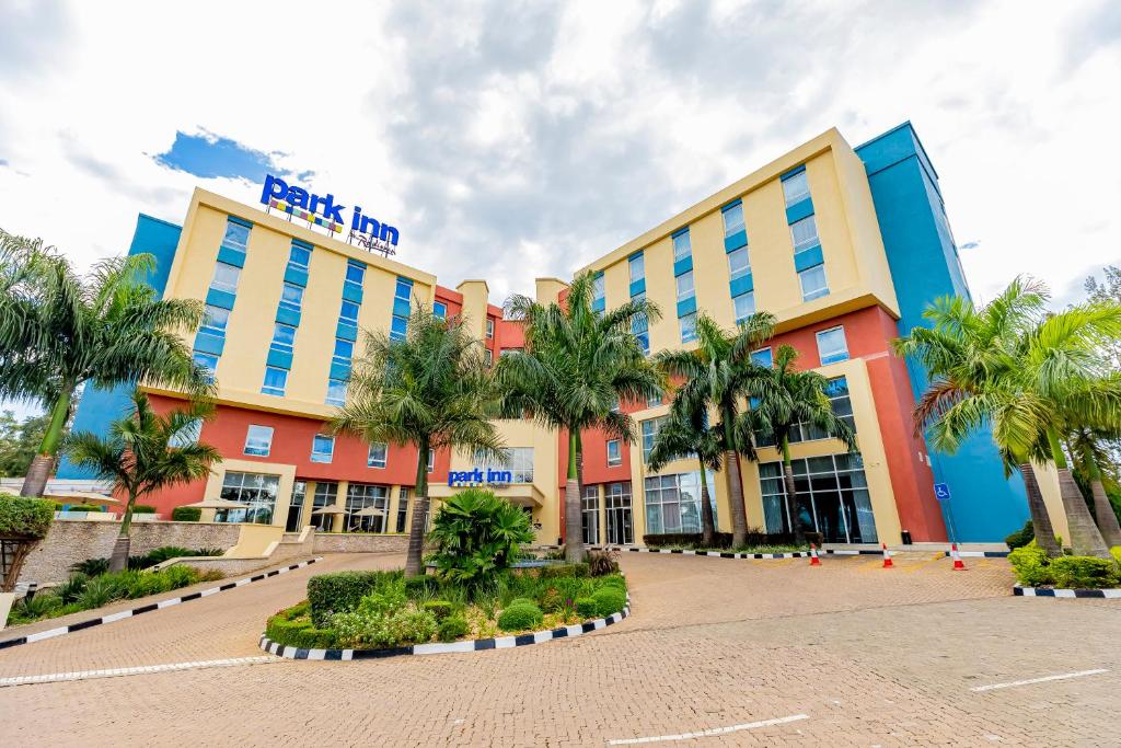 a hotel with palm trees in front of it at Park Inn by Radisson, Kigali in Kigali