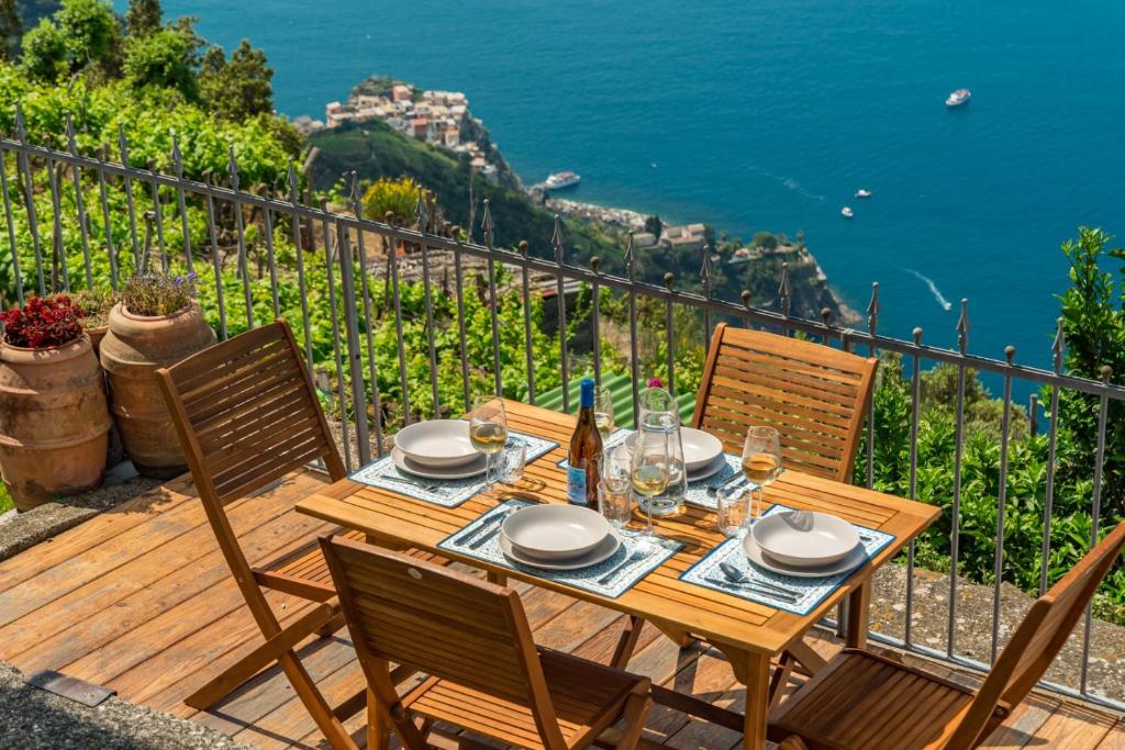 a wooden table and chairs on a deck with a view of the ocean at Orizzonte damare in Volastra