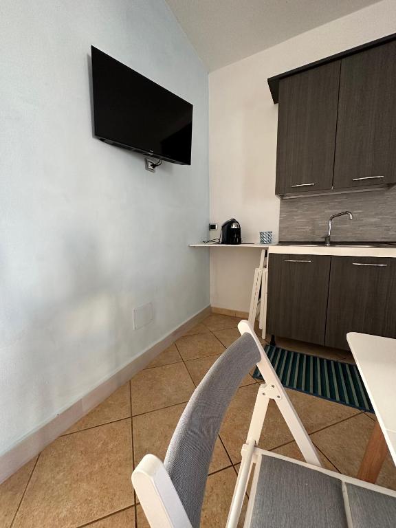 a kitchen with a chair and a television on the wall at Villa Santo Stefano in Monopoli