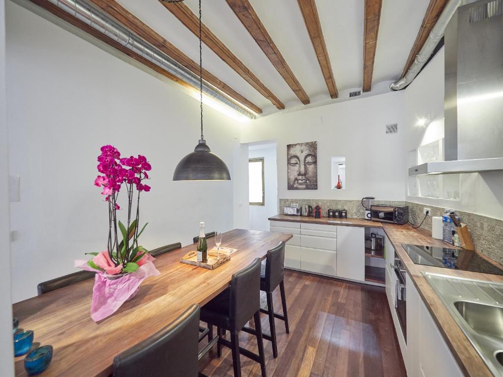 a kitchen with a large wooden counter with purple flowers on it at Barcelonaforrent Alessandra Central Ramblas Apartment in Barcelona