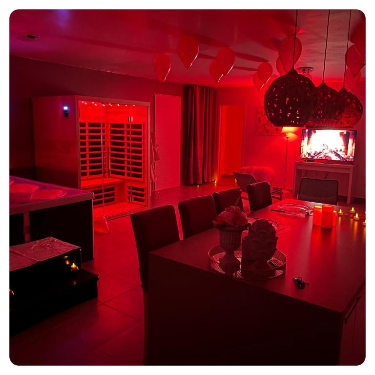 a red living room with a table and a dining room at Nid’Ange in Piolenc