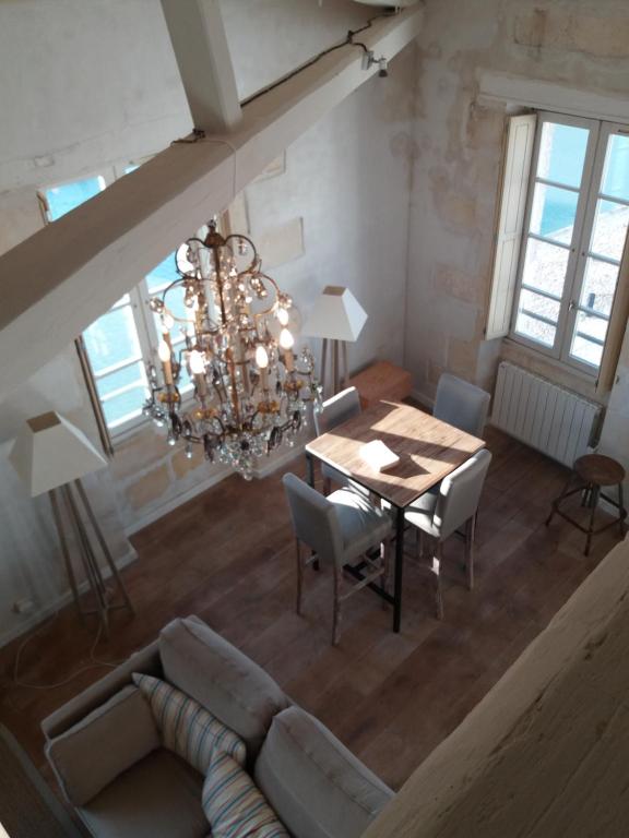 - un salon avec une table et un lustre dans l'établissement XVIII Century Gem With Magnificent Views Of The Harbour with a private garage, à Saint-Martin-de-Ré