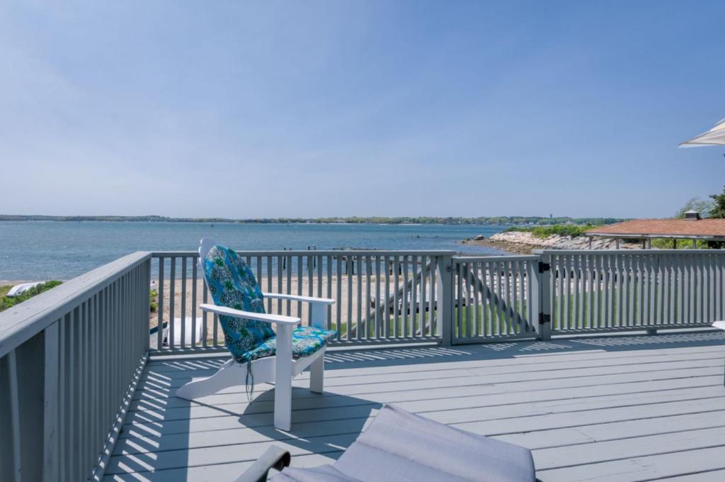 einen Stuhl auf einem Deck neben dem Wasser in der Unterkunft 5 Bryant Road Bourne Sunset Cottage in Buzzards Bay