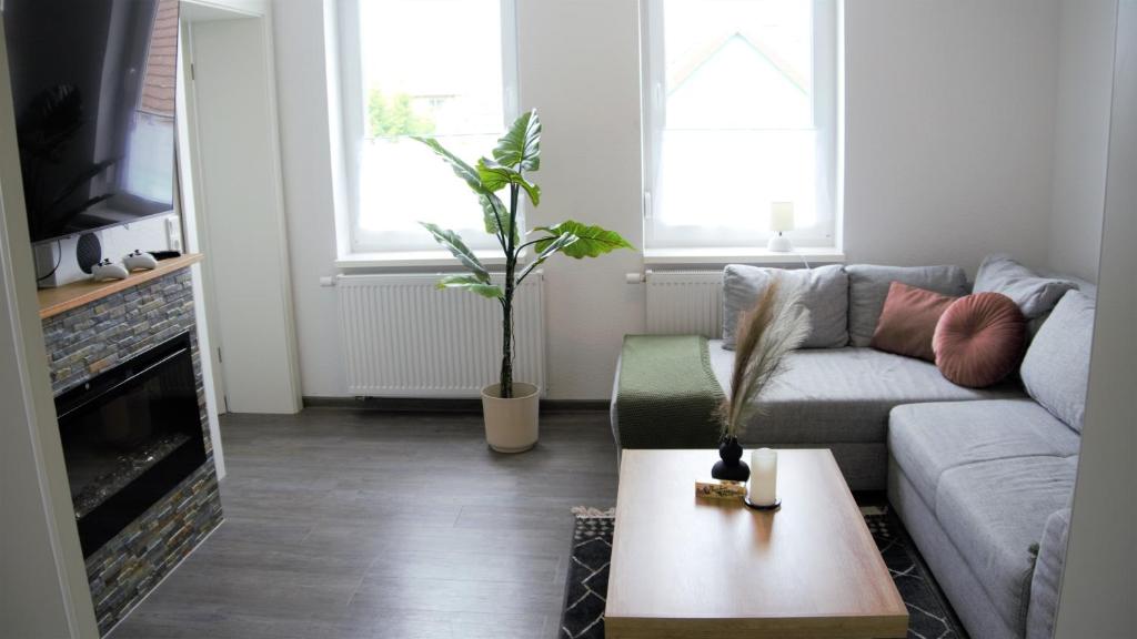 uma sala de estar com um sofá e uma mesa de centro em FeWo Rübezahl mit Kamin em Bad Harzburg