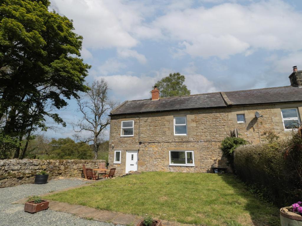 an old stone house with a large yard at The Hollow in Hexham