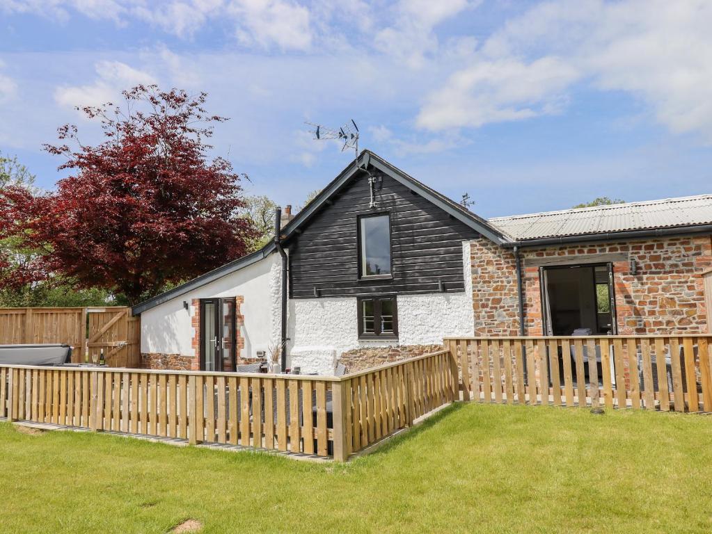 a house with a wooden fence in a yard at Strawberry Bank - Kingfisher in Holsworthy