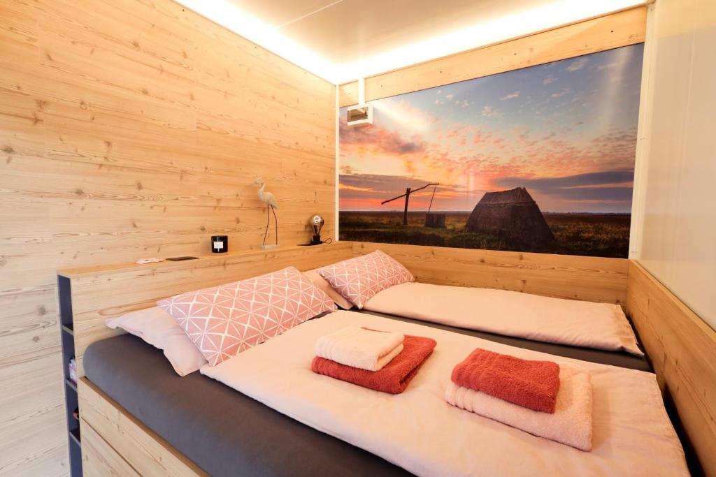 Bett in einem Zimmer mit einem großen Fenster in der Unterkunft Tiny Zwick in Apetlon