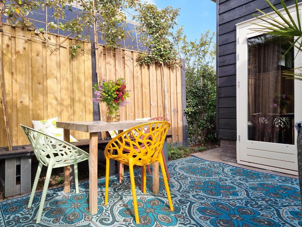 a patio with a table and two chairs on a rug at Vakantiehuis Dishoek DI04 in Dishoek