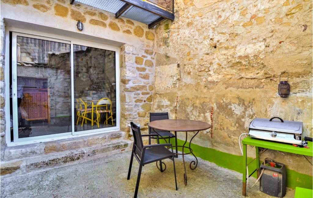 patio ze stołem i krzesłami oraz oknem w obiekcie 1 Bedroom Stunning Home In Villeneuve-les-avignon w mieście Villeneuve-lès-Avignon