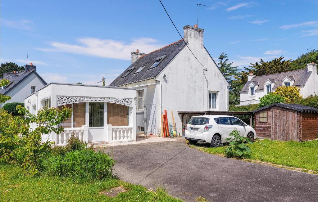uma casa branca com um carro estacionado na garagem em 4 Bedroom Beautiful Home In Molan-sur-mer em Moëlan-sur-Mer
