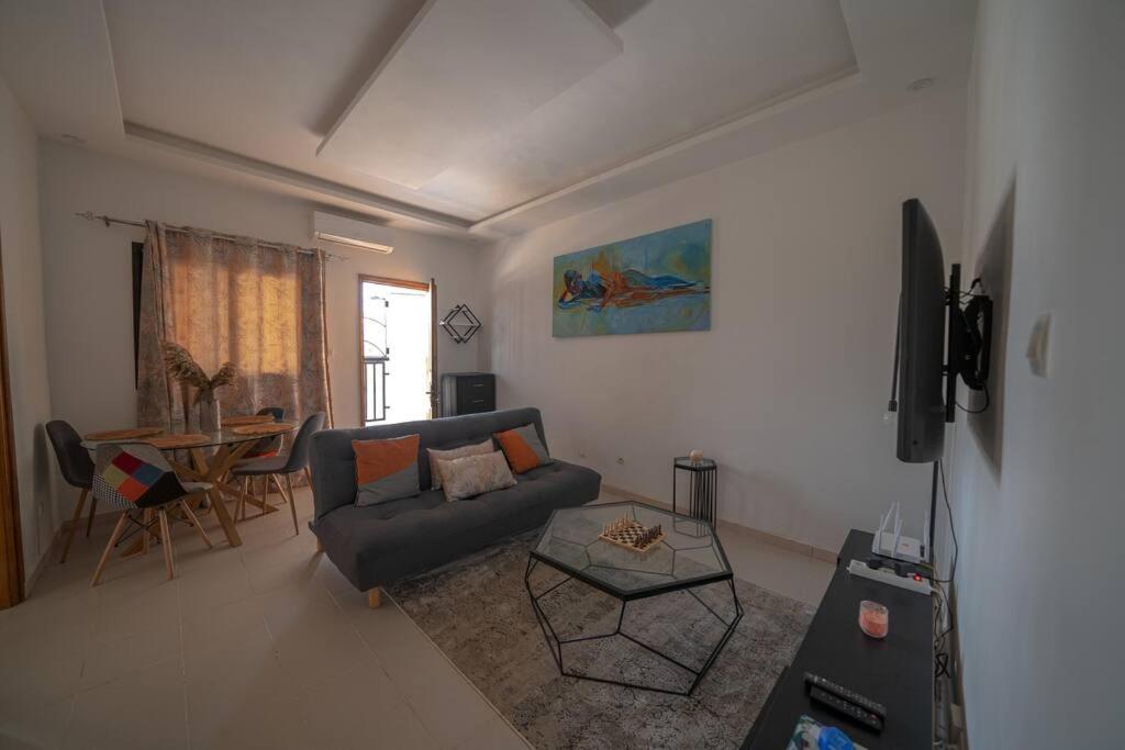 sala de estar con sofá y mesa en Le charmant en Dakar