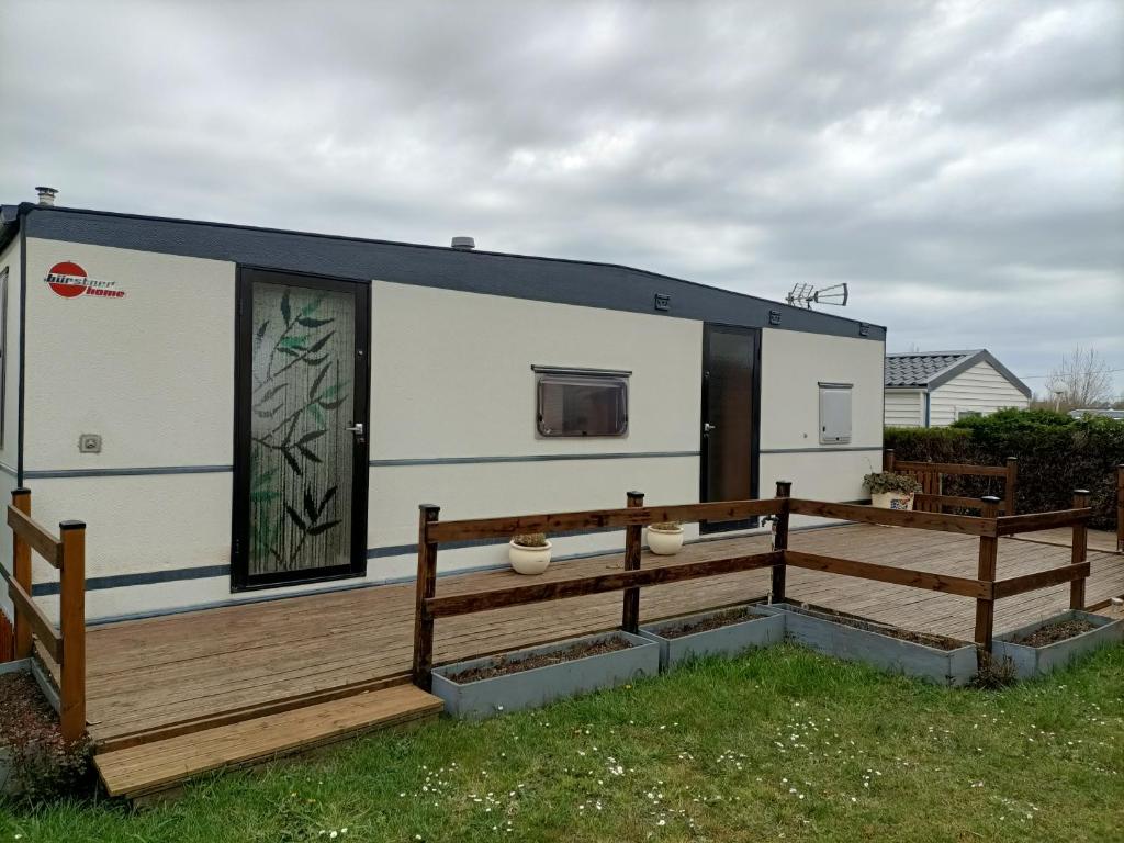 una casa pequeña con terraza y puerta en Mobil home inter, en Berck-sur-Mer