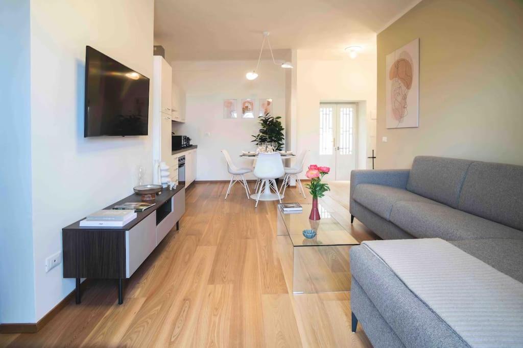 uma sala de estar com um sofá e uma sala de jantar em Atmosfere Terrace View Apartment em Bérgamo