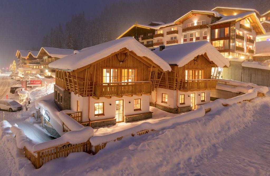 a house covered in snow at night at FIRSTpeak Appartements und Chalets in Zauchensee