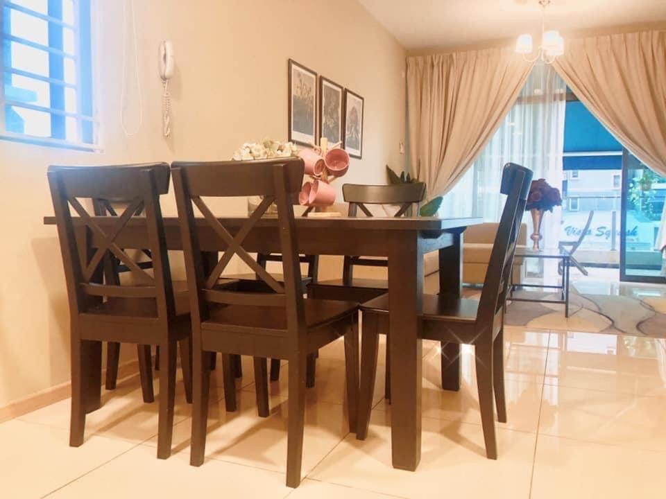 a dining room table and chairs in a room at Dzora Vista Alam in Shah Alam