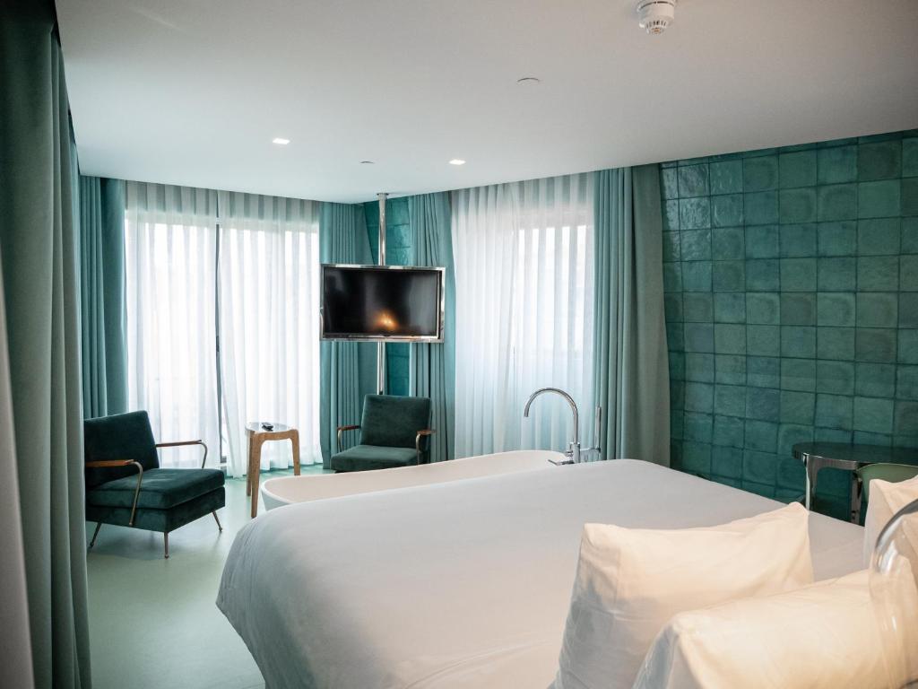 a hotel room with a bed and a tv on the wall at WC by The Beautique Hotels in Lisbon