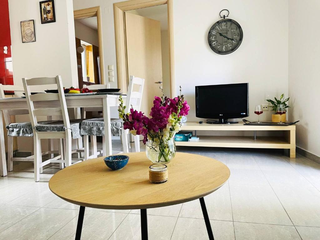 a vase of flowers on a table in a living room at Cozy Nest - 2min To Beach, 6min Walk To Old Town in Chania Town