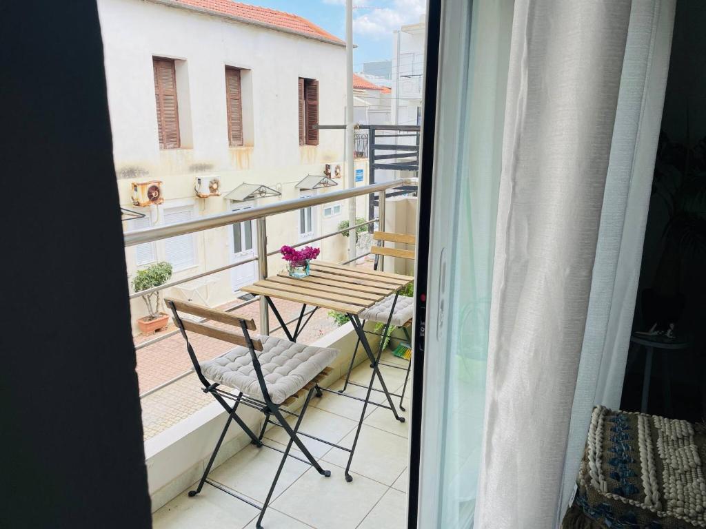 balcone con tavolo e sedie. di Cozy Nest - 2min To Beach, 6min Walk To Old Town a Chania