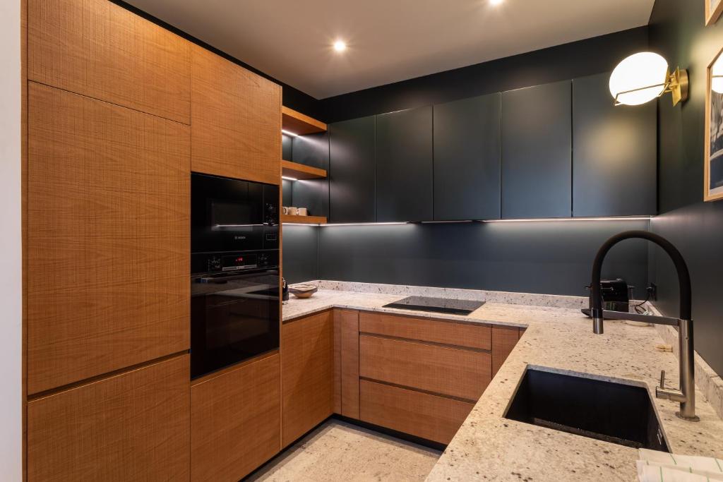 a kitchen with dark wood cabinets and a sink at Le Goya - Appartement 4 chambres centre ville de Rennes in Rennes